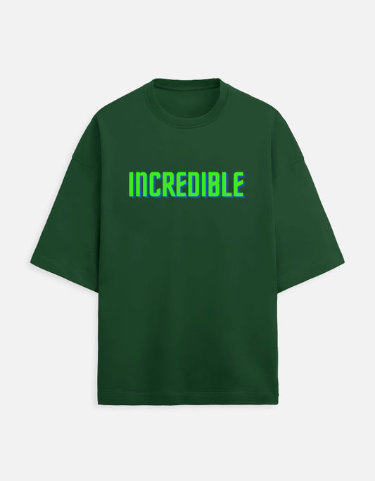 Front view of a green t-shirt with the word INCREDIBLE printed in 3D neon green and blue block letters.
