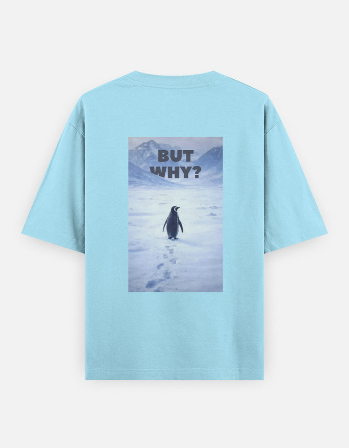 Back view of a blue t-shirt featuring a rectangular graphic of a lone penguin walking across a snowy Antarctic landscape toward mountains with the text "BUT WHY?" in bold grey letters.