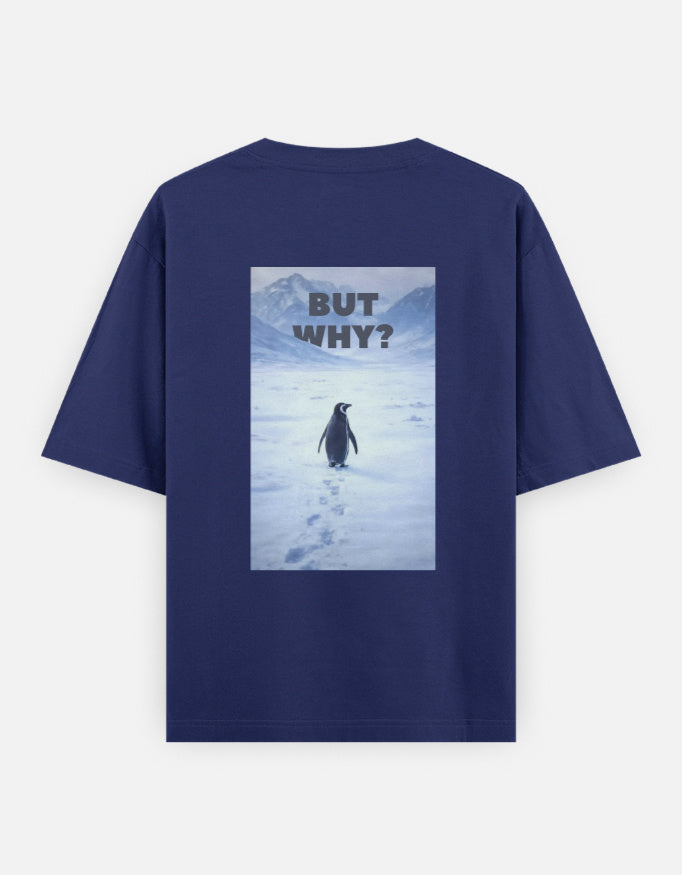 Back view of a royal blue t-shirt featuring a rectangular graphic of a lone penguin walking across a snowy Antarctic landscape toward mountains with the text "BUT WHY?" in bold grey letters.