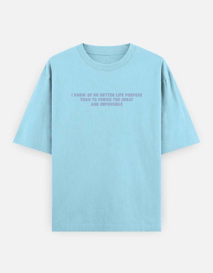 Front view of a blue oversized t-shirt featuring the quote "I know of no better life purpose than to perish the great and impossible" printed in grey block letters across the chest.