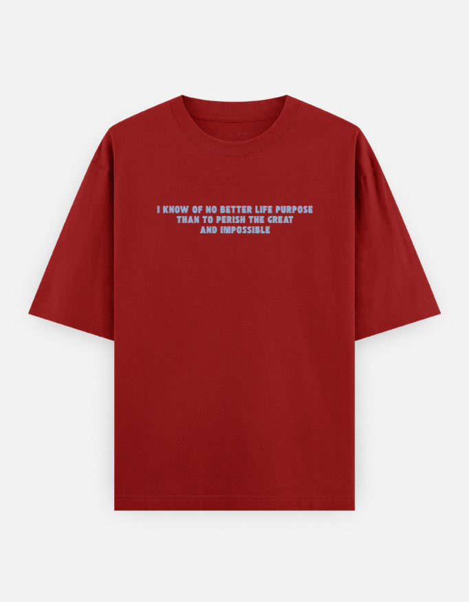 Front view of a red oversized t-shirt featuring the quote "I know of no better life purpose than to perish the great and impossible" printed in grey block letters across the chest.