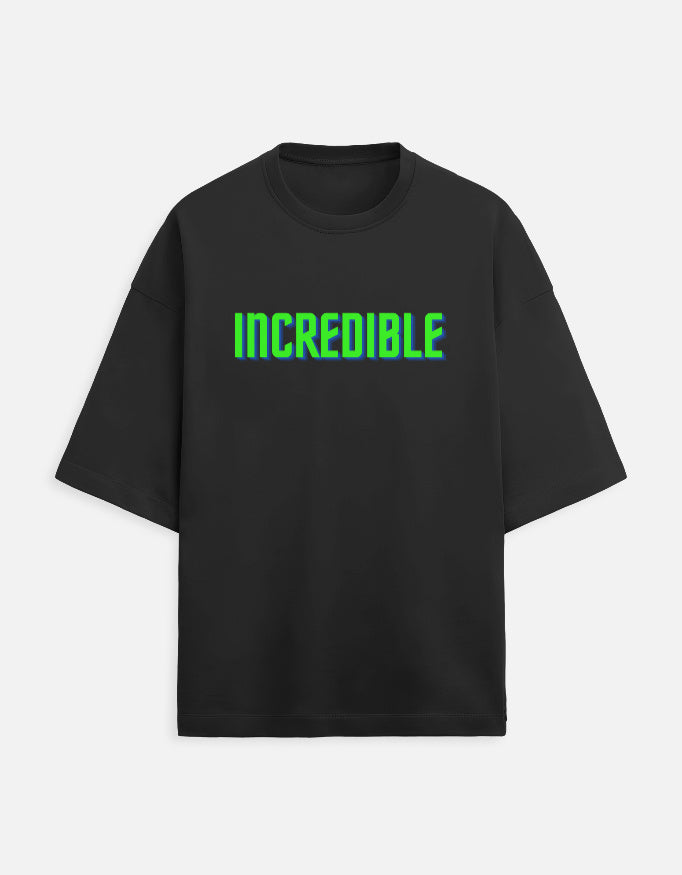 Front view of a black t-shirt with the word INCREDIBLE printed in 3D neon green and blue block letters.