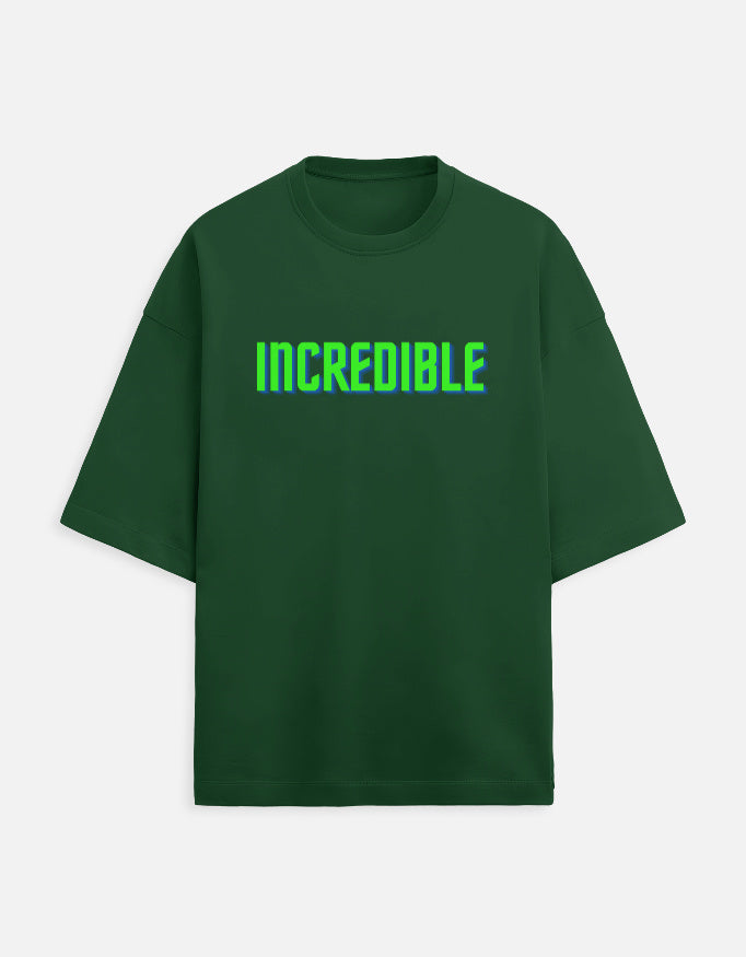 Front view of a green t-shirt with the word INCREDIBLE printed in 3D neon green and blue block letters.